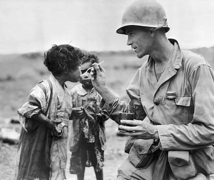 „Americký voják sdílí svůj příděl se dvěma japonskými dětmi, Okinawa, 1945