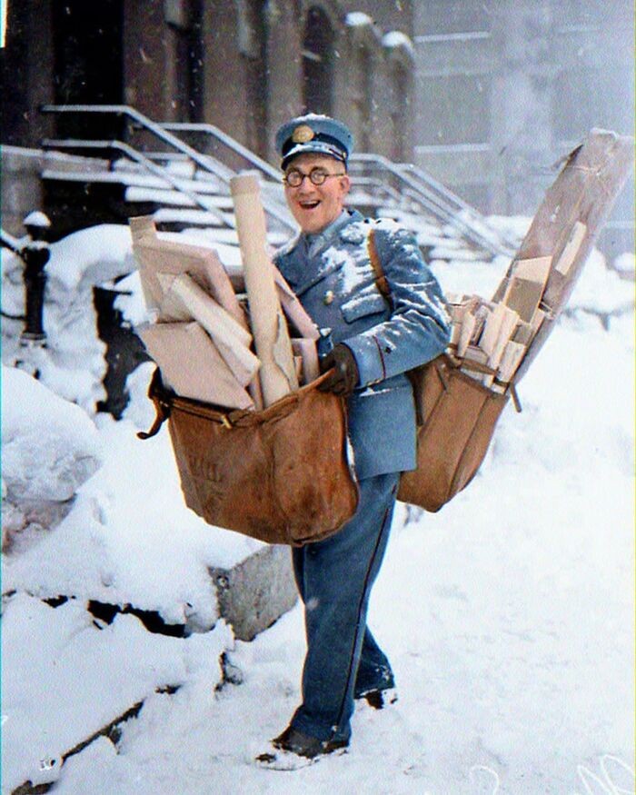 "Pošťák pózuje s těžkými balíky a vánočními dopisy, Chicago, 1929. Kolorovaná fotka."