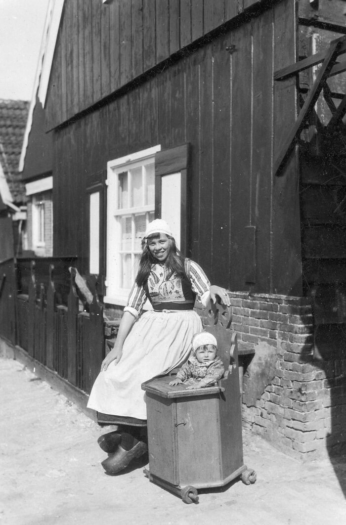 16. Młoda holenderska mama i jej dziecko w drewnianym wózku, 1929