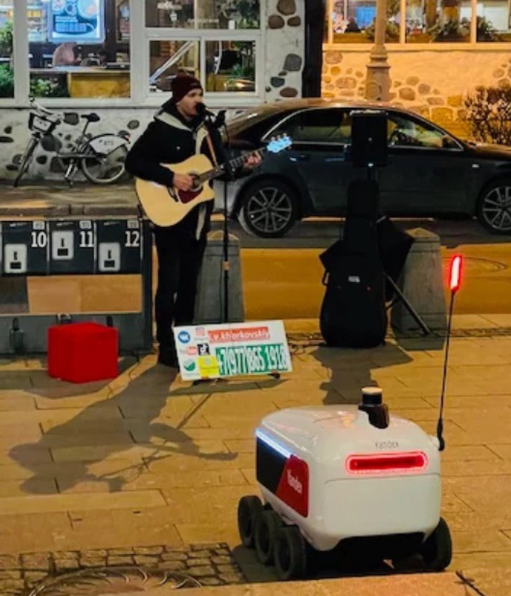 "Robot dostawczy postanowił przerwać pracę i posłuchać występu ulicznego muzyka."