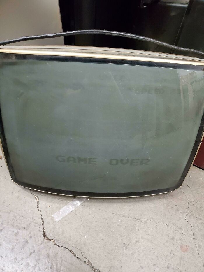 "Zepsuty stary telewizor z napisem GAME OVER wypalonym na ekranie"