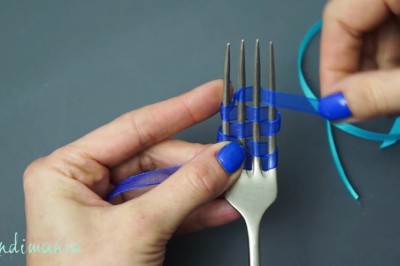 Owija widelec kolorową wstążką i po chwili zaciąga! W prosty sposób stworzyła coś pięknego! 