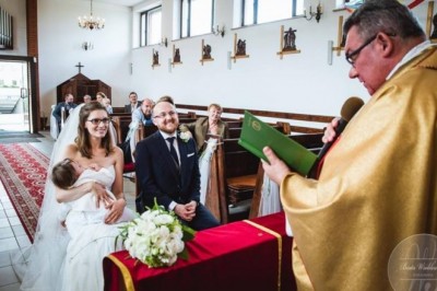 Panna Młoda w bieli siedzi przed ołtarzem i karmi piersią trzymane dziecko. Postawa księdza zaskoczyła wielu wiernych