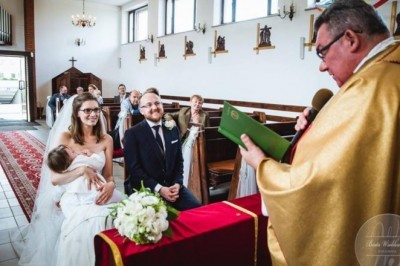 Panna Młoda w bieli siedzi przed ołtarzem i karmi piersią dziecko. Postawa księdza zaskoczyła wiernych