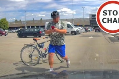 Agresywny rowerzysta biega po parkingu za samochodem. Nagranie z kamery