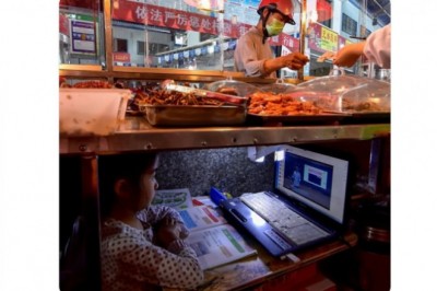 Mała dziewczynka z Chin uczy się online pod straganem swoich rodziców